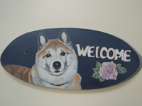 ペットロスの方がペットのリアルな似顔絵の注文（オーダー）前に見る作品～薔薇の花の横で立体感ある愛犬が出迎えるウエルカムボードのグッズ